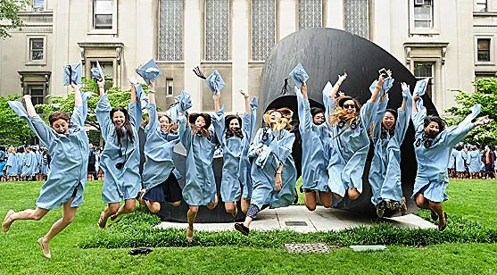 A bunch of grads in caps and gowns jump in front of The Curl.