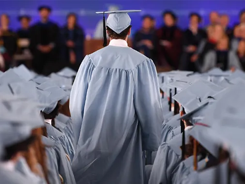 A graduate walks up the aisle