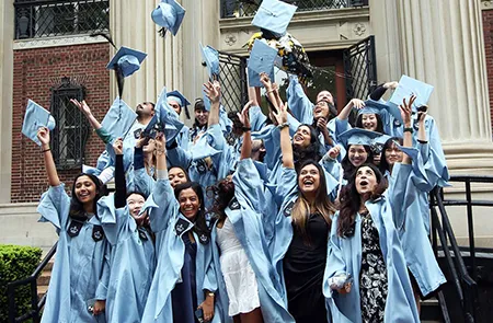 A group of students throws mortar boards in the air
