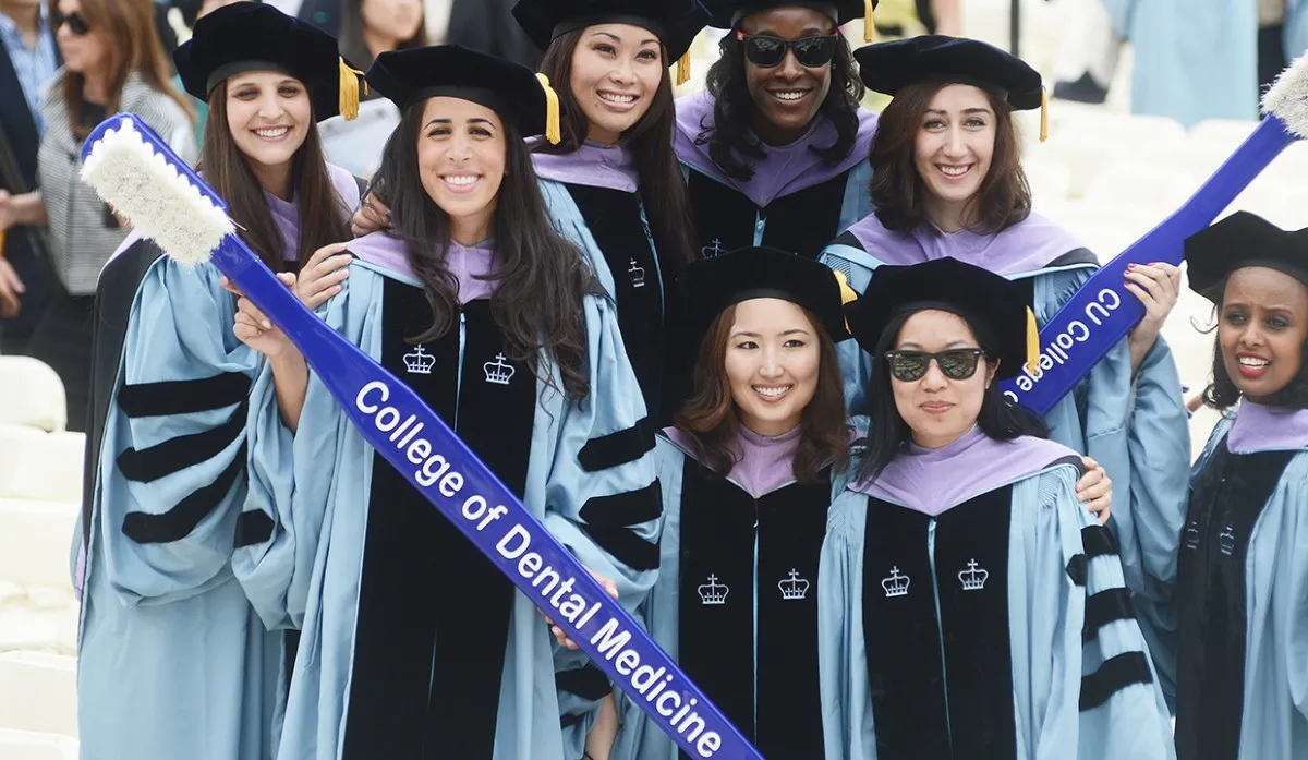 Graduating students holding “College of Dental Medicine” sign