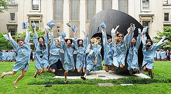 A bunch of grads in caps and gowns jump in front of The Curl.