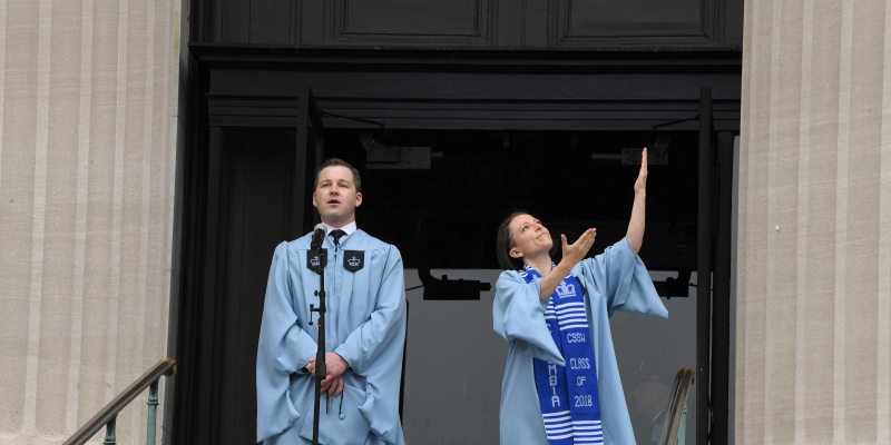 2018 graduating students singing and signing at university commencement
