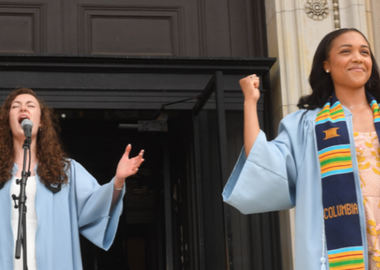 Graduating students singing and signing the National Anthem at University Commencement.