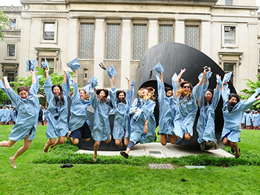 University graduates jumping and cheering on Morningside campus 