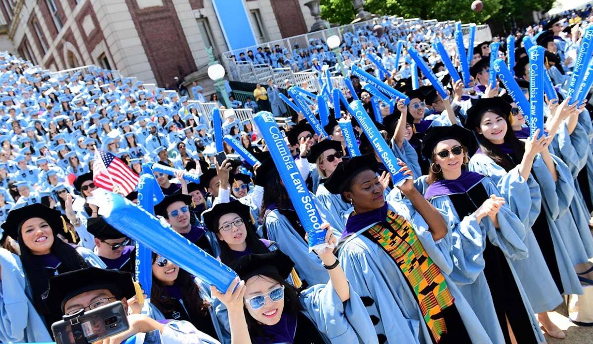 Columbia Law School graduates holding inflatable shakers